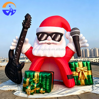 Arche gonflable géante Père Noël rockeur avec guitare, microphone et boîtes cadeaux pour l'entrée de centre commercial, la cour ou les événements de Noël