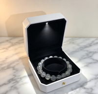 Boîtier carré en PU blanc mat avec structure à rabat, doublure en flocage noir, couvercle à rabat, perles lumineuses LED intégrées, aimant haut de gamme