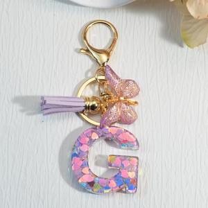 Popular venta directa de fábrica llavero de resina rosa púrpura 26 letras brillo pequeño colgante mariposa borla en forma de corazón para pequeño - Product Image 6
