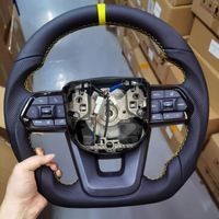 Volant noir à boutons en cuir pleine fleur avec surpiqûres rouges et détails jaunes GR pour Toyota Land Cruiser LC79 LC76 LC300