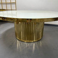 Table de mariage circulaire moderne avec structure en acier inoxydable et plateau en verre, idéale pour les dîners et les mariages