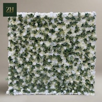 Mur de fleurs artificielles en soie blanches et vertes, roses et hortensias avec panneau de verdure pour la décoration de mariage en bord de mer