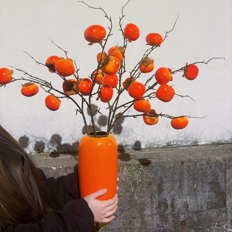 Jarrón de cerámica naranja extra grande con 25 caquis regordetes.