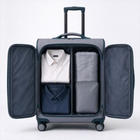 Valise à roulettes souple grise et turquoise avec compartiment avant zippé, deux poches en filet et poignée télescopique