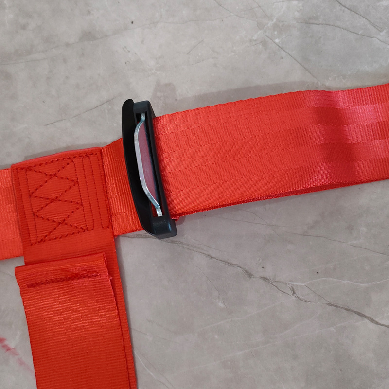 Ceinture de sécurité rouge à quatre points avec verrouillage latéral.