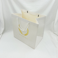 Sac en papier carte blanc de luxe personnalisé avec logo en feuille d'or pour faire du shopping Sac d'emballage pour cadeau vêtement robe avec poignée