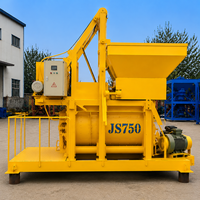 Bétonnière à double arbre JS750 750L 35m3/h Jaune avec poulie de levage orange et moteur gris-vert