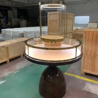 Vitrine ronde en verre sur piédestal, table de présentation circulaire de luxe, comptoir d'îlot pour bijoux avec base en bois pour boutique