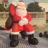 Vente directe d'usine, grandes décorations gonflables de Père Noël personnalisables avec impression de logo, utilisées pour la décoration de Noël et la mise en place d'événements.