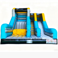 Parcours d'obstacles avec toboggan et trampoline, château gonflable extérieur décoré, petite machine distributrice, jeu de carnaval, fosse à mousse