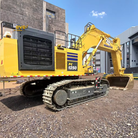 Excavatrice PC1250 8 d'occasion avec moteur de 775 CV, PLC et boîte de vitesses, modèle 2021, excellent état, livraison rapide