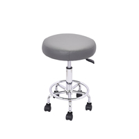 Tabouret de salon roulant réglable avec siège rembourré rond gris, anneau de repose-pieds et cinq roulettes pour institut de beauté