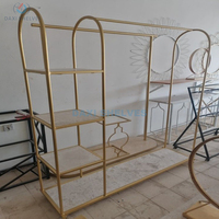 Présentoir à vêtements doré personnalisable pour magasin de vêtements, avec étagère à chaussures et porte-sacs