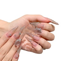 Ongles artificiels de luxe faits à la main, couleur rose nude transparente, style stiletto, avec dégradé de paillettes fines et strass multi-tailles dispersés