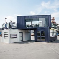 Maisonnette Apple Cabin en acier blanc et bleu marine, conteneur modulaire à double étage en forme de L avec terrasse et balcon pour la vie en famille en plein air