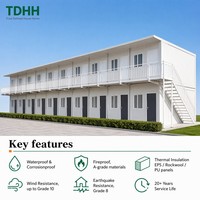 Dormitoire préfabriqué TDHH à deux étages avec panneaux blancs, couloir long avec garde-corps et escalier