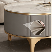 Table basse ovale moderne de luxe en pierre frittée avec revêtement en cuir et pieds en métal doré, structure en bois pour salon