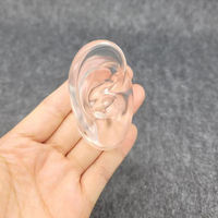 Service audio ITE, prothèses auditives BTE présentant des modèles d'oreille souple hautement transparents en caoutchouc humain pour démontrer l'IEM