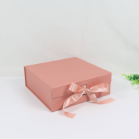 Boîte cadeau pliante à ruban carré fleurs de petite taille avec cadeau de feux d'artifice à la main