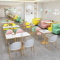Ensemble de mobilier moderne pour restaurant et café : banquette rose, chaises en métal doré et table en marbre avec sièges banquetaux