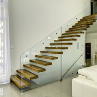 Escalier flottant en cantilever avec balustrade en verre trempé, main courante en métal noir, marches en chêne massif pour projets de construction