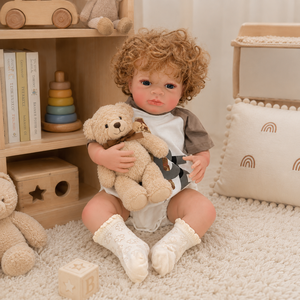 BAkwbwBY Bambola Reborn Caucausa da 18 Pollici con Corpo in Vinile e Tessuto, Capelli Biondi Ricci, Occhi Aperti Luminosi e Tutina con Stampa Orsetto - Product Image 1