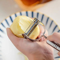Slimme 2-in-1 roestvrijstalen handmatige keukenhulp, duurzame metalen snijder en schiller voor fruit en groenten.