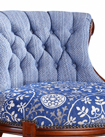 Fauteuil capitonné antique avec dossier à carreaux bleus et blancs, assise à motif floral, garniture à clous et pieds tournés sculptés