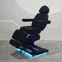 Meubles de salon de beauté modernes entièrement noirs, table de massage à 4 moteurs rotatifs, fauteuil de soin du visage électrique inclinable de luxe, lit de spa