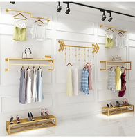 Support mural noir pour présentation de vêtements, idéal pour les boutiques et la décoration intérieure des magasins de prêt-à-porter