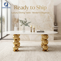 Table de banquet ovale de luxe pour hôtel, avec plateau en marbre blanc et pieds en acier inoxydable doré, pour événements et mariages.