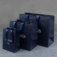 Sacs en papier noir enduit avec logo blanc imprimé sur mesure haut de gamme pour l'emballage de cadeaux et les soins personnels