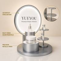 Présentoir cosmétique multi-niveaux pliable en acrylique avec éclairage LED et panneau arrière rond pour comptoir de magasin de beauté