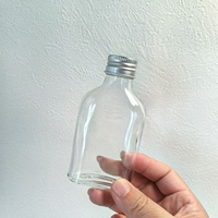 Botella plana de vidrio con logotipo personalizado de 200ml en forma de cilindro con tapa de rosca para envasar café frío o agua en estado vacío