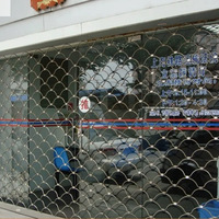Vente en gros de porte enroulable en treillis métallique en acier inoxydable, volet roulant pour magasin