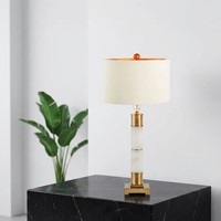 Lampe de table colonne moderne de luxe en laiton doré avec base en pierre texturée marbre et abat-jour en tissu pour la décoration de projets hôteliers et de villas