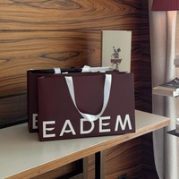 Sac en papier rouge vin avec impression de logo personnalisé, pelliculage brillant, poignées en ruban blanc pour l'emballage de produits de salon de coiffure, de beauté et de vêtements