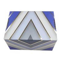 Boîte-cadeau de luxe bleu profond avec lignes géométriques argentées et plateau intérieur en relief pour les produits de santé de thé de qualité supérieure