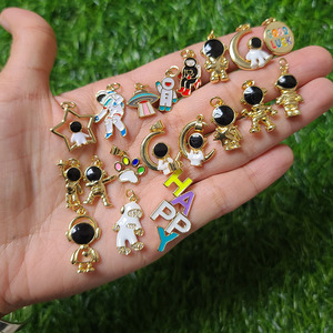 จี้รูปนักบินอวกาศเคลือบทอง 18K รุ่น JS1634 สีดำขาว ทำจากทองเหลืองเคลือบเงา พร้อมจี้รูปนักบินอวกาศและจรวด - Product Image 1