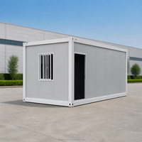Maison modulaire en conteneur préfabriquée moderne avec fenêtre grillagée et porte ouverte pour usage de bureau sur chantier