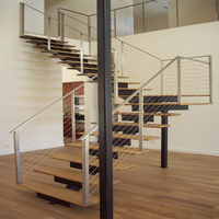 Escalier intérieur moderne à monopoutre avec garde-corps en câble et marches en bois massif