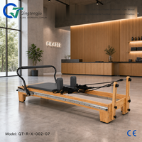 Reformer Pilates pleine longueur en bois de chêne gris anthracite avec barre de repose-pieds réglable pour studios commerciaux modernes