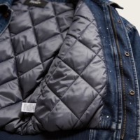 Veste streetwear en toile de coton premium 100% avec motif éclaboussures de peinture et bords effilochés, idéale pour un style urbain essentiel et un look robuste.