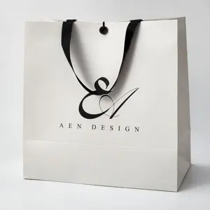 Flexografía Boutiques personalizadas Bolsa de papel blanco con logotipo para embalaje de regalo con bloqueo de botón