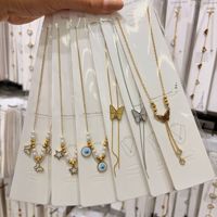 Collier pour femme en acier inoxydable plaqué or, avec chaîne à maillons, papillon, étoile et perles d'imitation, idéal pour les activités de plein air