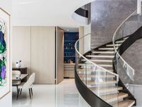 Escalier courbé avec rampes en acier inoxydable revêtu de noir et marches en bois massif, pour usage intérieur, design contemporain durable