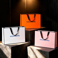 Sac cadeau en papier couché blanc avec impression de logo dégradé bleu et poignée noire côtelée effet ombré pour emballage de marque de luxe