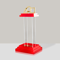 Trofeo de Acrílico Personalizado con Base Roja de Tres Niveles y Logotipos Geométricos Dorados para Regalos Corporativos
