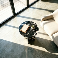 Table d'appoint géométrique moderne à base croisée en marbre Nero Marquina, idéale pour les salons contemporains et les studios d'art minimalistes