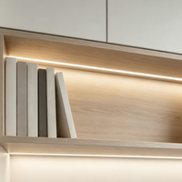 Bureau intégré minimaliste moderne avec bibliothèque, armoires fermées personnalisées et étagères ouvertes pour le rangement et la présentation dans un bureau à domicile calme